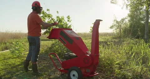 Wood chipper machine man shredding tree branches Stock Footage 297376875