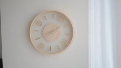 Wood clock showing time on a white wall Stock Footage 340725338