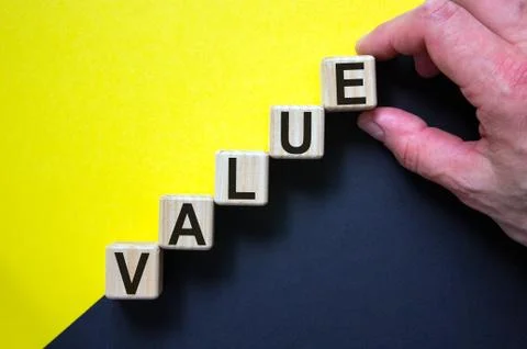 Wood cubes with word 'value' stacking as step stair on paper yellow and black Stock Photos