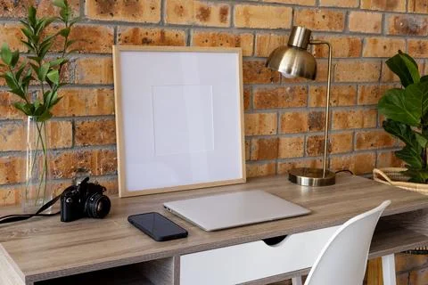 Wood empty frame with copy space, plants and technology devices on desk against Stock Photos