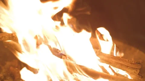A wood fire burning under the moon and stars on a calm winter night. Video stock 112402545