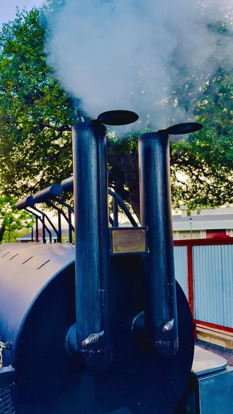 Wood fire smoke from double chimney of meat barbecue grill smoker Stock Footage 303597404