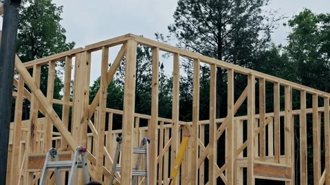 Wood framing in progress for new house construction at wooded site Vídeos de archivo 319841429