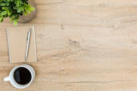 Wood hipster desk table with notebook and pen, coffee and tree pot. Top view Stock Photos