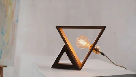 Wood lamp triangle shape. Loft cube wooden lamp on the table. Handmade lamp Stock Footage 127779636