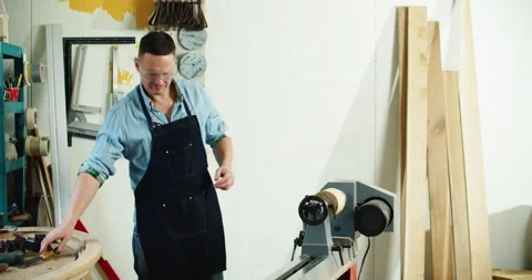 Wood lathe. A carpenter in goggles sharpens wood on a lathe. Stock Footage 197065604