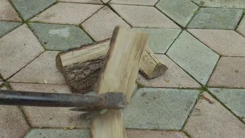 Wood logs arranged on a patterned stone surface with an axe poised above, Stock Footage 328294966