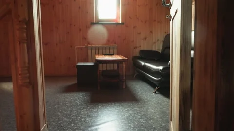 Wood panel room with leather couch and table under bright window light Stock Footage 316856820