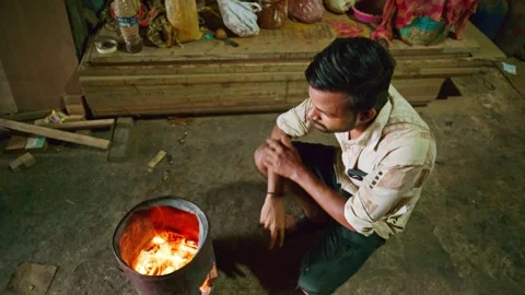 Wood polisher seeks warmth from flame into workshop Stock Footage 301437662
