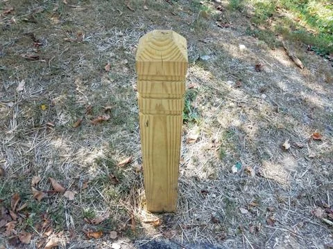 Wood post or pole or bollard in ground with straw Stock Photos