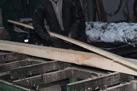 Wood processing. Cutting logs on the boards. In the winter process a tree. Stock Photos