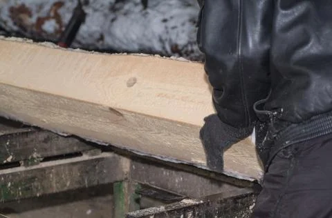 Wood processing. Cutting logs on the boards. In the winter process a tree. Stock Photos