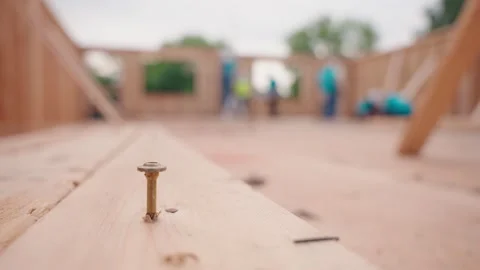 Wood Screw in Foreground with Construction Crew Working in Background Stock Footage 345240620
