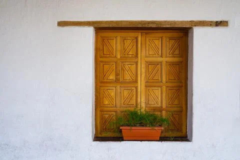 Wood shutter window with decorative pattern. Potted plant on the windowsill Stock Photos