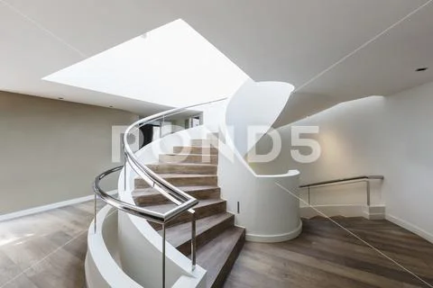 Wood spiral staircase in modern luxury home showcase interior Stock Photos