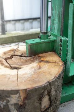 Wood splitter machine cracking a big tree slice, close up Stock Photos