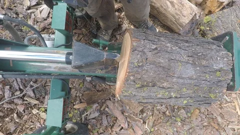 Wood splitter machine at work, top view. Track out to show man using it Stock Footage 91757052