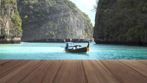 Wood top table on top view beautiful sea and wooden boat with mountain in t.. Fotos de archivo