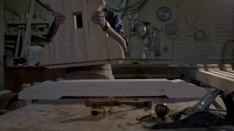 Wood worker assembling two pieces of wood together in his workshop Stock Footage 98844031