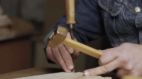 A wood worker cuts out a dovetail on a pine board with a chisel. dovetail joi Stock Footage 166340950