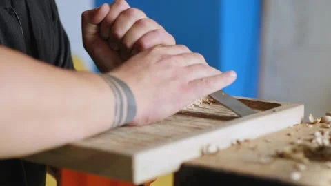 A woodcarver processes the walnut board with a flat impact chisel. A craftsma Stock Footage 144244165