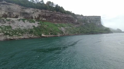Wooded limestone cliffs of the Niagara Gorge above the calm emerald water Stock Footage 345996069