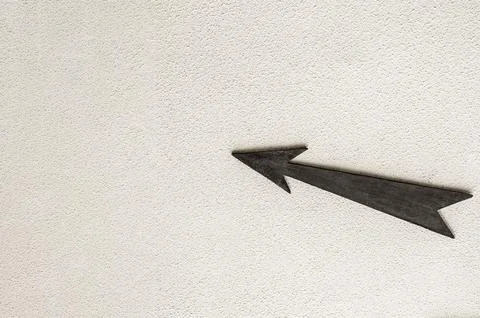 Wooden arrow pointer to the left up on light background Stock Photos