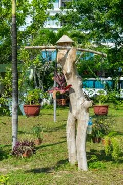 Wooden asian statue in park with pots and hat Stock Photos