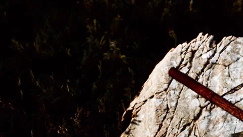 Wooden axe resting on a rough stone surface in a natural setting Stock Footage 340978203
