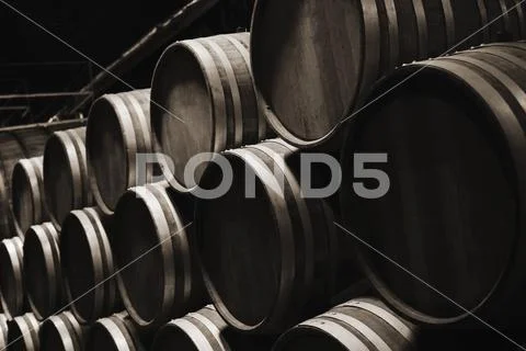 Wooden barrels in dark wine factory hall Stock Photos