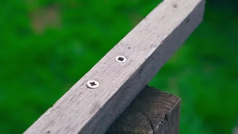 Wooden bars are twisted by two large self-tapping screws, close-up. Connecting Stock Footage 240270902