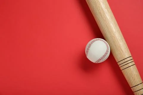 Wooden baseball bat and ball on red background, flat lay. Space for text Stock Photos