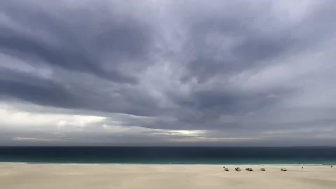 Wooden beach huts along empty sandy shoreline at Praia de Chaves 库存影片 302537247
