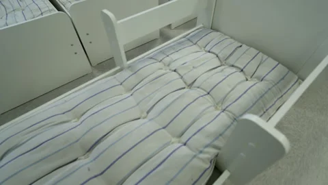 Wooden bed frame supports comfortable white mattress 動画素材 334140895