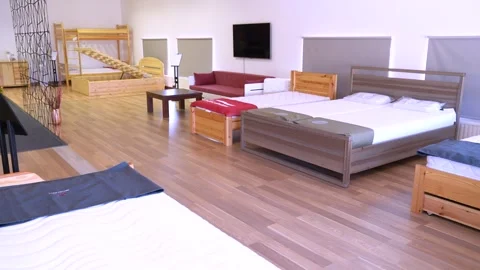 Wooden bed frames, mattresses and sofas displayed in spacious factory showroom Stock Footage 313046222