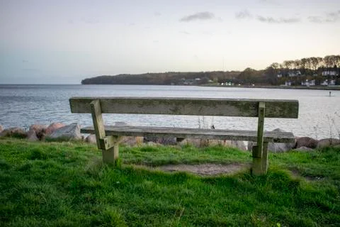 Wooden bench close by the sea Stock Photos