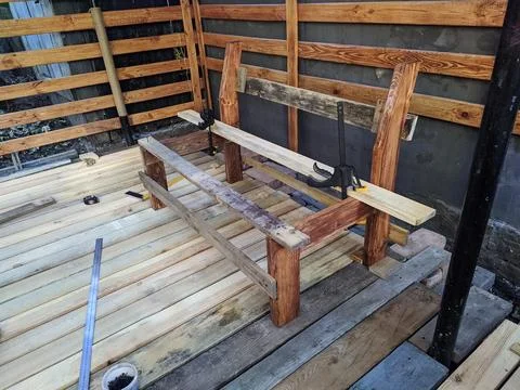 Wooden bench construction process on a deck. Stock Photos