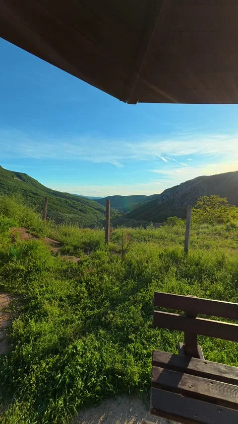 Wooden bench sits under a rustic shelter. Sicevo Gorge, Serbia. Vertical Stock Footage 337058135