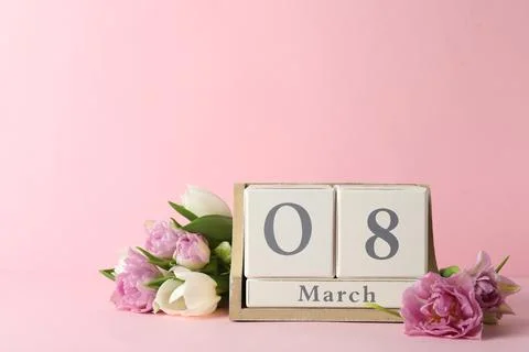 Wooden block calendar with date 8th of March and tulips on pink background, s Stock Photos
