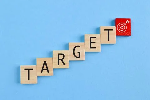 Wooden block with text TARGET and dartboard symbol Stock Photos