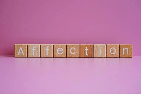 Wooden blocks form the text "Affection" against a pink background. Stock Photos