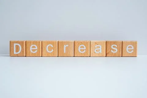 Wooden blocks form the text "Decrease" against a white background. Stock Photos