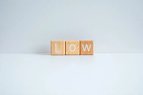 Wooden blocks form the text "Low" against a white background. Stock Photos