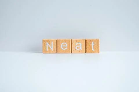 Wooden blocks form the text "Neat" against a white background. Stock-Fotos