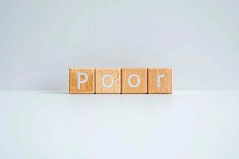 Wooden blocks form the text "Poor" against a white background. Stock Photos