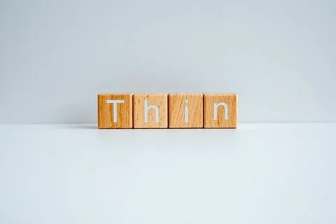 Wooden blocks form the text "Thin" against a white background. Stock Photos