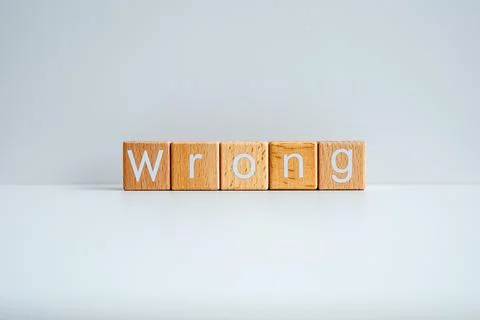 Wooden blocks form the text "Wrong" against a white background. Stock Photos