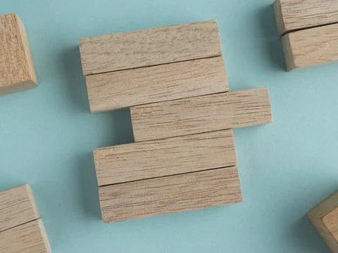 Wooden blocks with a missing section and yellow pushpin on a light blue bac.. Stock Photos