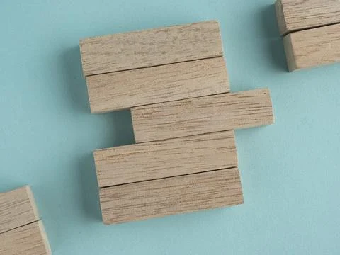 Wooden blocks with a missing section and yellow pushpin on a light blue bac.. Stock Photos
