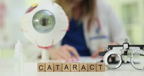 Wooden blocks spell Cataract with eye model and glasses on desk Stock Footage 314104632